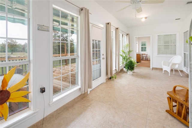 sunroom / solarium with a ceiling fan and visible vents