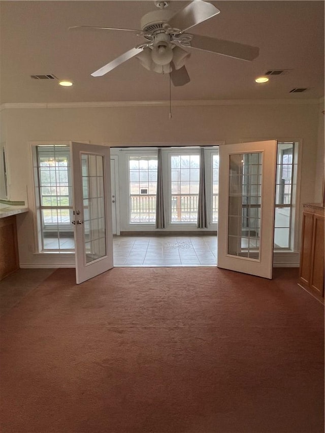 interior space featuring light carpet, french doors, ornamental molding, and visible vents