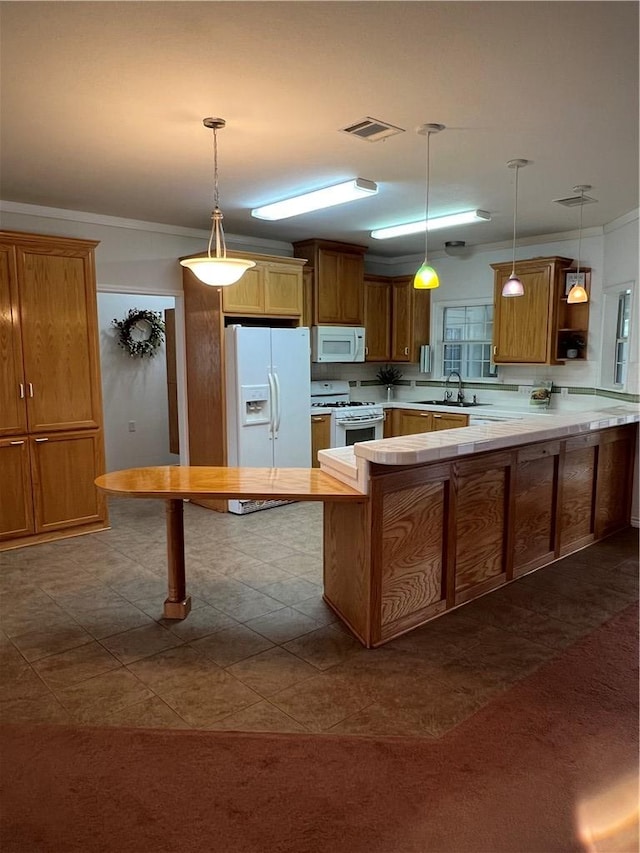 kitchen featuring a peninsula, white appliances, a sink, visible vents, and light countertops