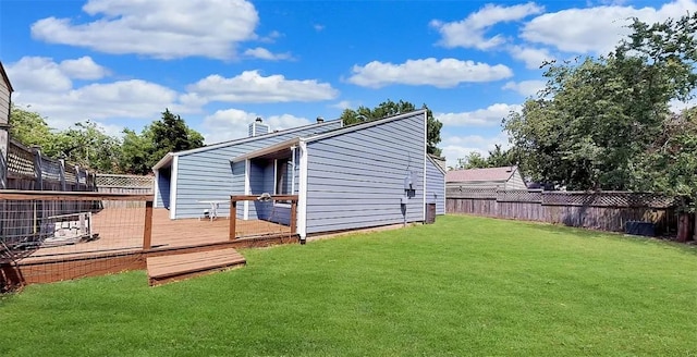 rear view of property featuring a wooden deck and a yard