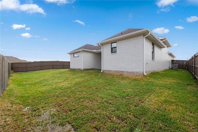 rear view of house with a lawn and central air condition unit