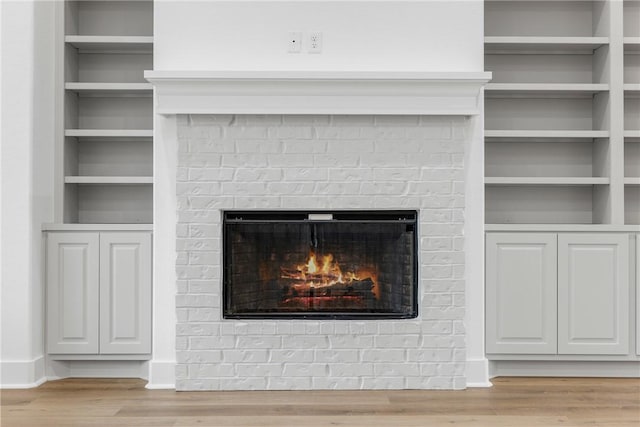 interior details featuring hardwood / wood-style flooring and a brick fireplace