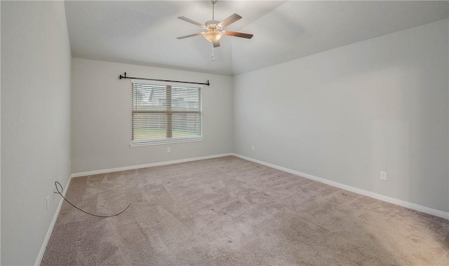 carpeted spare room featuring ceiling fan, lofted ceiling, and baseboards