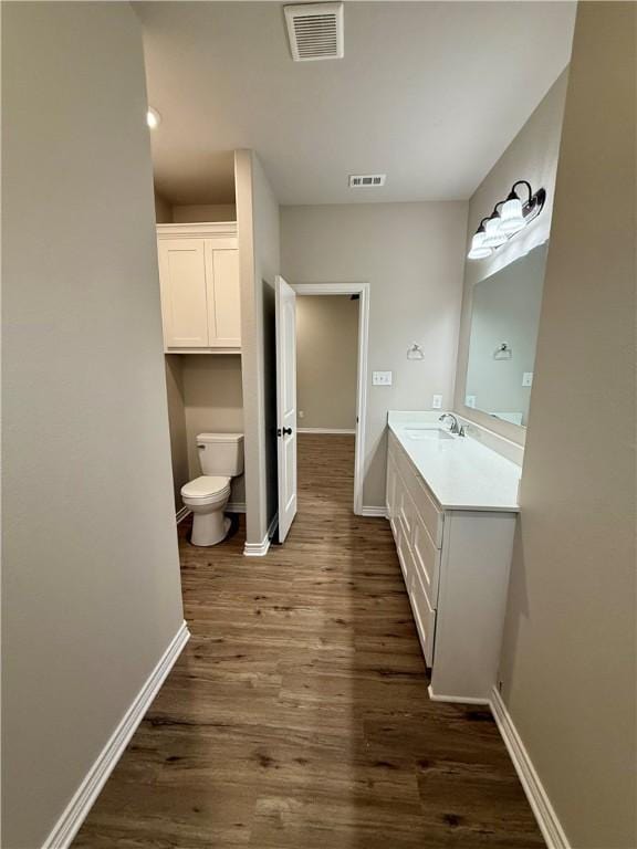 bathroom with vanity, hardwood / wood-style floors, and toilet