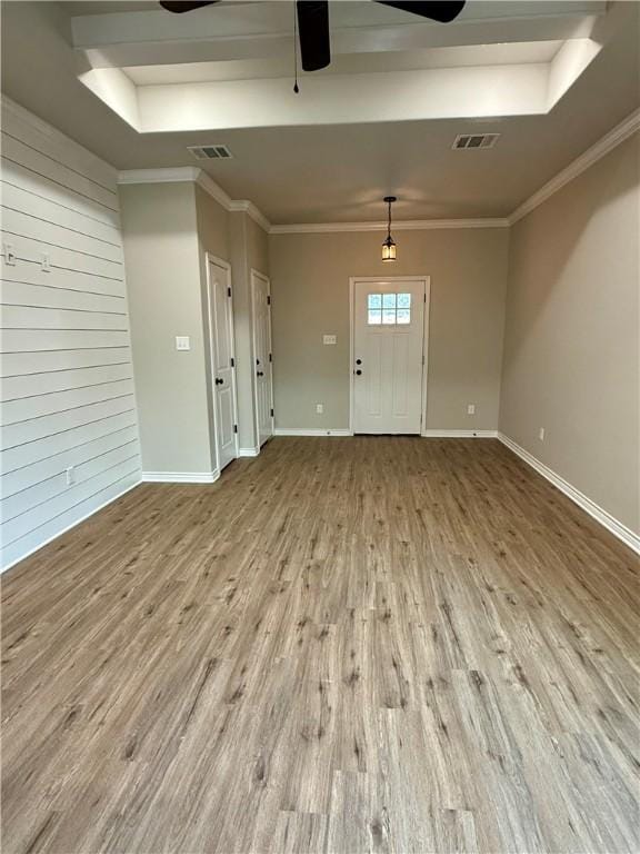 entryway featuring ceiling fan, ornamental molding, a raised ceiling, and light hardwood / wood-style floors