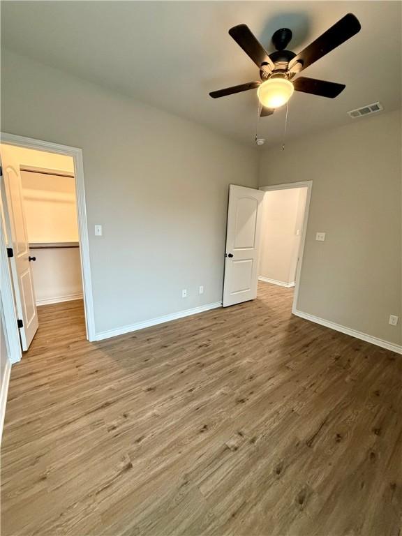 unfurnished bedroom with ceiling fan and light wood-type flooring