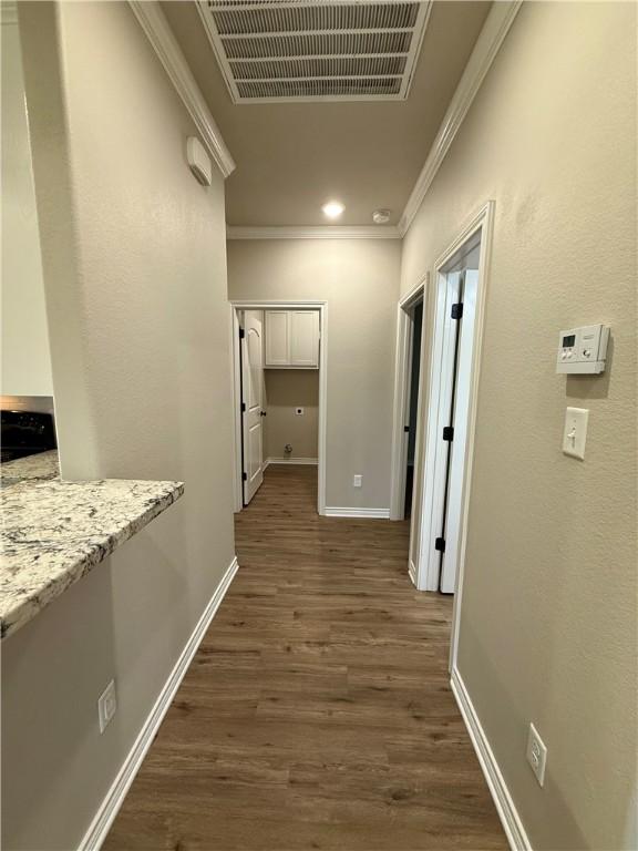 hallway featuring ornamental molding and dark hardwood / wood-style floors