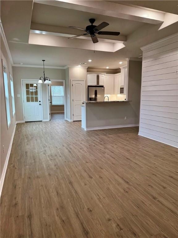 unfurnished living room featuring crown molding, ceiling fan with notable chandelier, and light hardwood / wood-style floors