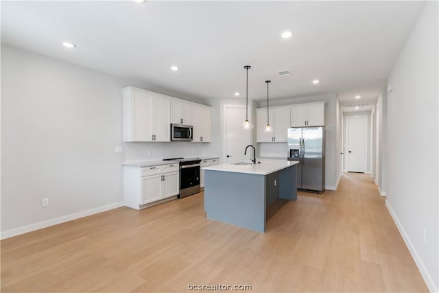 1405 Conner St, Bryan, TX 77808 - kitchen featuring pendant lighting, a center island with sink, white cabinets, and stainless steel appliances