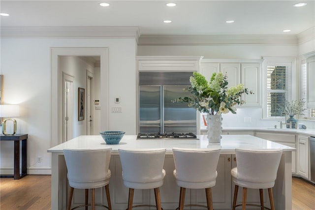 kitchen with a center island, a kitchen bar, white cabinetry, and stainless steel appliances