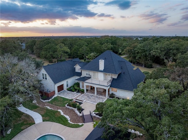 aerial view at dusk with a view of trees