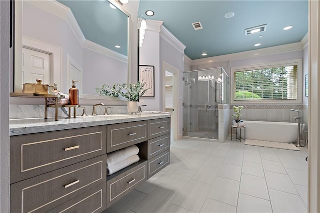 bathroom featuring ornamental molding, a shower stall, vanity, a freestanding bath, and tile patterned flooring