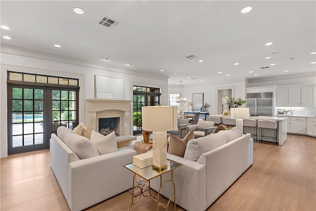 living room featuring recessed lighting, crown molding, visible vents, and light wood-type flooring