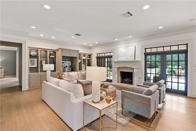living room featuring light wood-style floors, ornamental molding, recessed lighting, and a high end fireplace