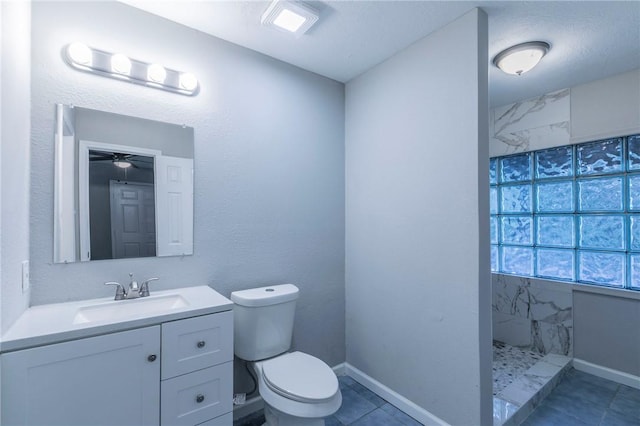 bathroom featuring tile patterned floors, a textured ceiling, toilet, tiled shower, and vanity