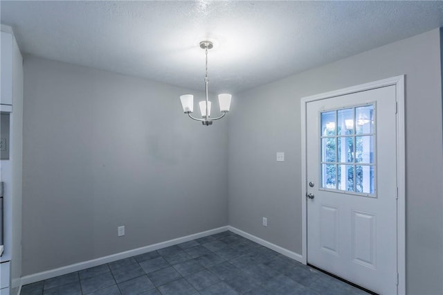 doorway to outside with a textured ceiling and a notable chandelier