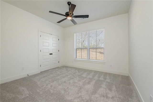 carpeted spare room with ceiling fan