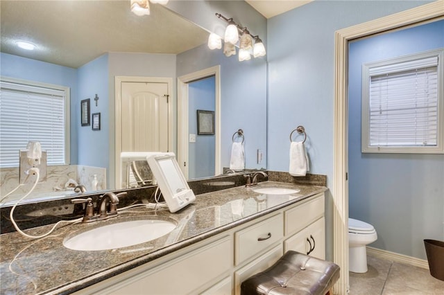 2703 Wood Ct, Bryan, TX 77808 - bathroom with tile patterned floors, double vanity, toilet, and baseboards