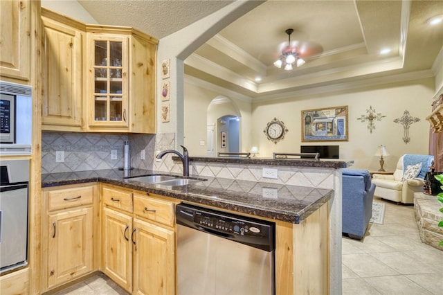 2703 Wood Ct, Bryan, TX 77808 - kitchen with appliances with stainless steel finishes, arched walkways, a sink, light brown cabinets, and crown molding
