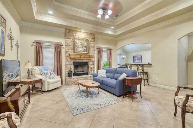 2703 Wood Ct, Bryan, TX 77808 - living room with arched walkways, ceiling fan, a raised ceiling, crown molding, and a fireplace