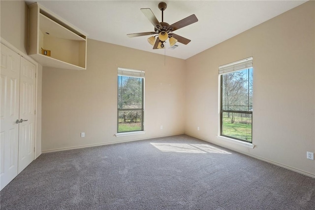 unfurnished room featuring carpet, baseboards, and a wealth of natural light