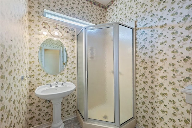 bathroom featuring wallpapered walls and a stall shower