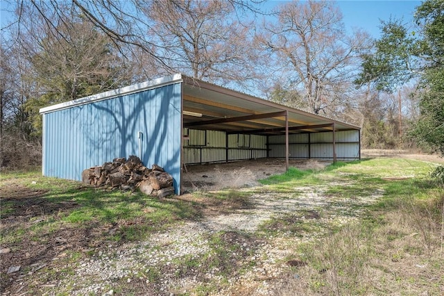 view of pole building featuring driveway and a carport