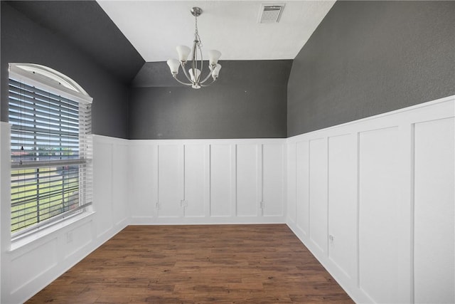 2099 Positano Loop, Bryan, TX 77808 - empty room featuring a decorative wall, a chandelier, dark wood-style floors, lofted ceiling, and a wainscoted wall