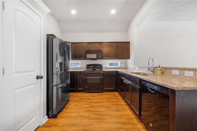 2099 Positano Loop, Bryan, TX 77808 - kitchen featuring black appliances, a sink, light wood-style flooring, dark brown cabinetry, and a peninsula