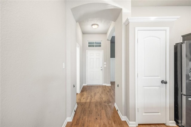 2099 Positano Loop, Bryan, TX 77808 - hall with arched walkways, wood finished floors, and baseboards