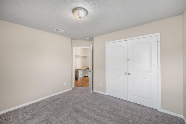 2099 Positano Loop, Bryan, TX 77808 - unfurnished bedroom with carpet floors, baseboards, a textured ceiling, and a closet