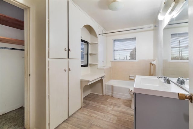 bathroom featuring a bathing tub, vanity, plenty of natural light, and wood-type flooring