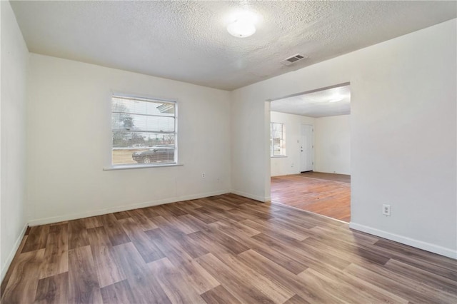 spare room featuring hardwood / wood-style flooring and a textured ceiling