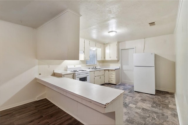 kitchen featuring sink, a textured ceiling, kitchen peninsula, white appliances, and white cabinets