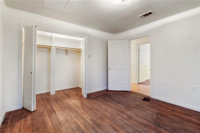 unfurnished bedroom featuring dark hardwood / wood-style floors and a closet