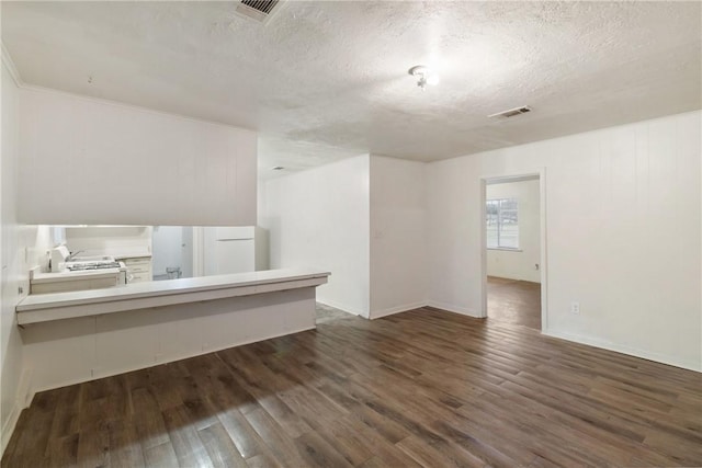 interior space with a textured ceiling and dark hardwood / wood-style flooring