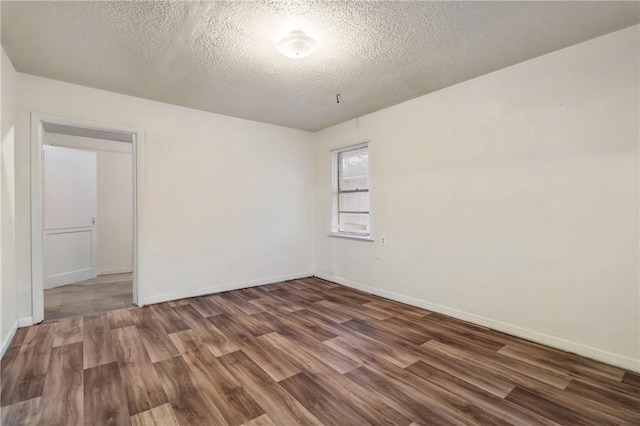 unfurnished room featuring dark hardwood / wood-style floors and a textured ceiling