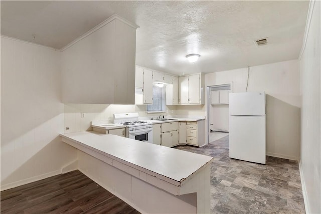 kitchen with white cabinetry, sink, white appliances, and kitchen peninsula