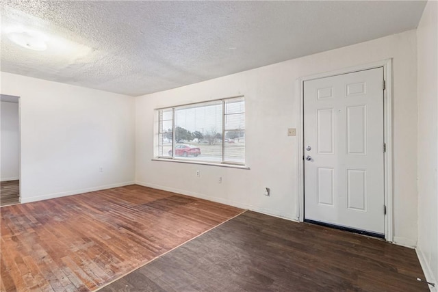 foyer entrance with dark wood-type flooring and a textured ceiling