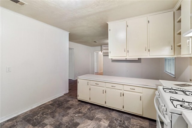 kitchen with white cabinetry, kitchen peninsula, and white gas stove