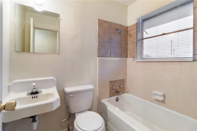 full bathroom featuring toilet, tiled shower / bath combo, and sink