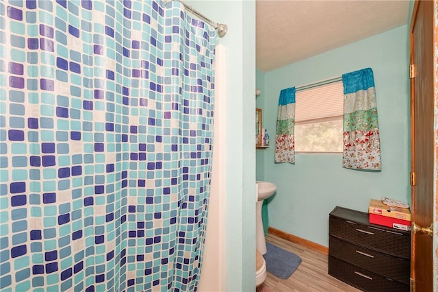 bathroom with hardwood / wood-style floors and toilet