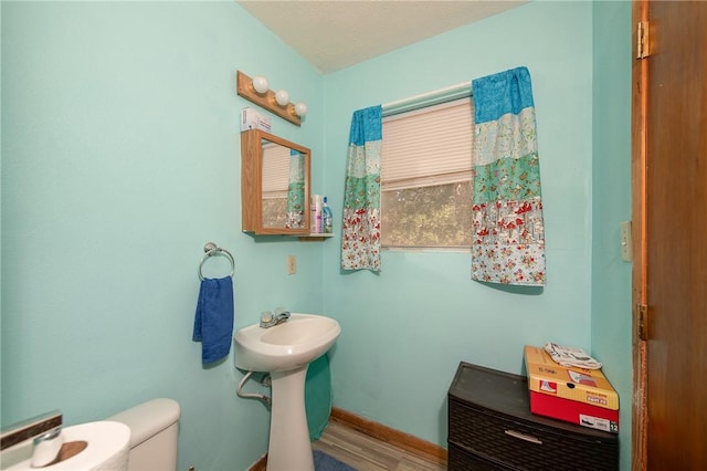 bathroom with hardwood / wood-style floors and toilet