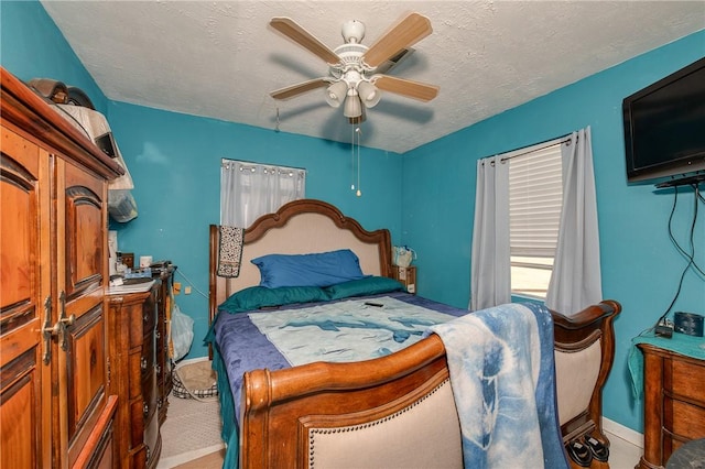 bedroom featuring ceiling fan and a textured ceiling