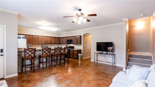 kitchen featuring arched walkways, a breakfast bar, open floor plan, a peninsula, and baseboards