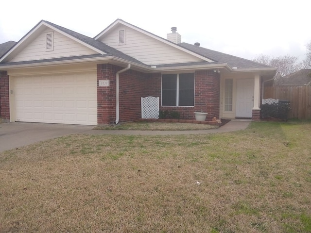 ranch-style home with a garage, brick siding, and a front yard