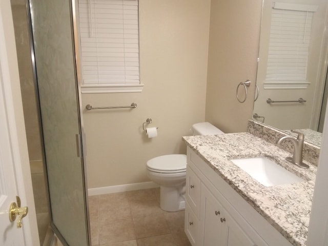 bathroom featuring a shower with door, toilet, vanity, tile patterned flooring, and baseboards