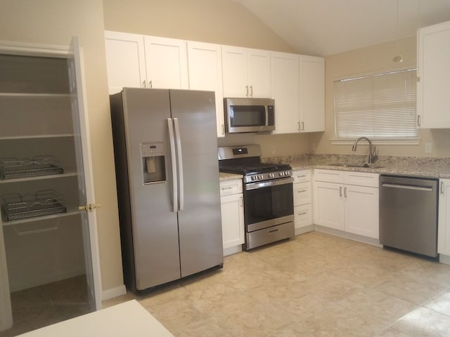 kitchen with appliances with stainless steel finishes, white cabinets, and a sink