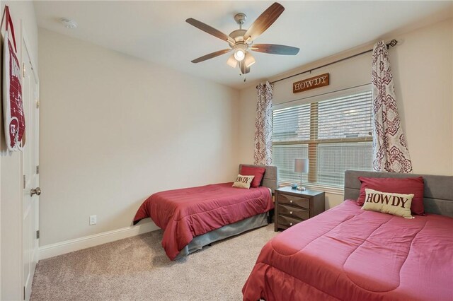 carpeted bedroom with baseboards and a ceiling fan