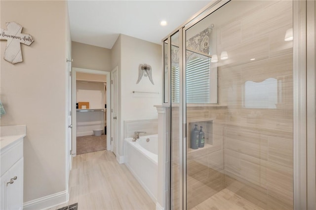 bathroom with vanity, a stall shower, and a garden tub